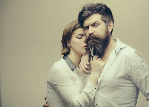 Conceito de barbearia ou cabeleireiro. Cabeleireiro mulher corta barba com tesoura. Homem com barba longa, bigode e cabelo elegante, fundo claro. Cara com penteado moderno visitando cabeleireiro — Fotografia de Stock