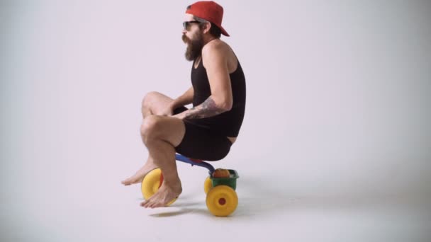 Смешной бородатый мужчина едет на велосипеде для детей — стоковое видео