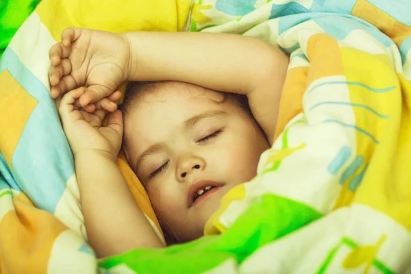 小さな赤ちゃんの夢を見ています。カラフルなブランケットで眠そうな赤ちゃん. — ストック写真