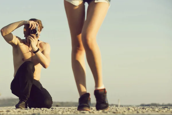 Modefotograaf. Kaukasische man met naakte torso vrouwelijke benen schieten op camera — Stockfoto