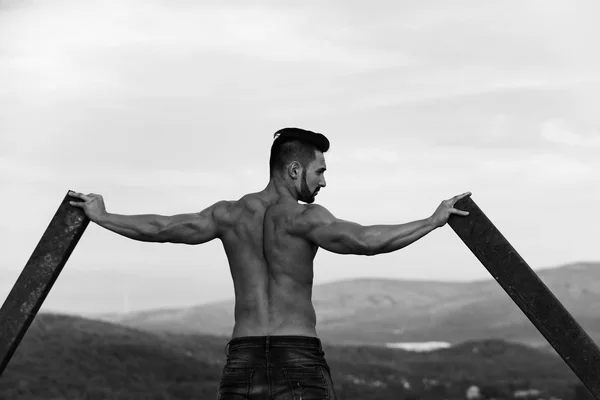 Homme avec une construction athlétique. homme avec entraînement musculaire du corps à la tige de fer rouillée — Photo