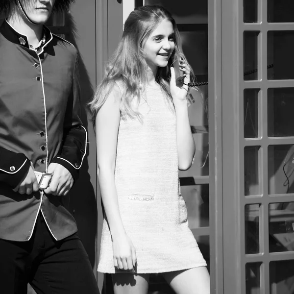 Communication and technology. Happy pretty girl talking on phone in red telephone box — Stock Photo, Image