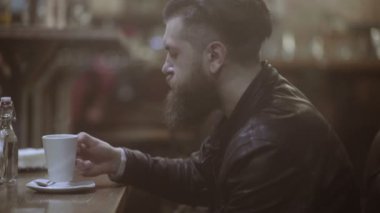 Yakışıklı adam portresi. Genç adam kahve ve pencereden dışarı bakar