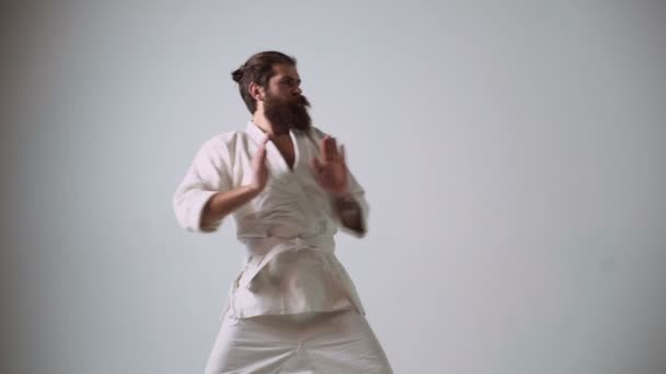 Ungeschicktes Karate fuchtelt mit den Händen und schlägt sich in die Leiste. Lustige Karate-Kämpferin im weißen Kimono — Stockvideo