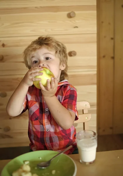 Baby eet een appel in de hut van een dorp. Ontbijt, ochtend, familie. — Stockfoto