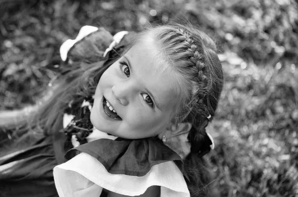A rapariga está a preparar-se para a escola. Menina bonito feliz com cabelo de trança sorrindo na grama verde — Fotografia de Stock