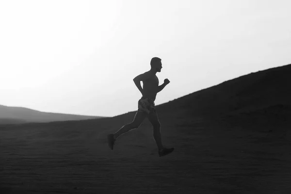 Concept van hardlopen. Man runner uitgevoerd in Duin bij zonsondergang — Stockfoto
