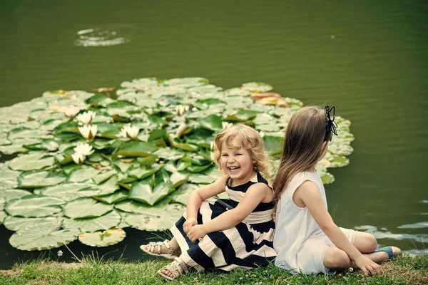 Niños sonrisa feliz en el paisaje verde del lago. Germinación y crecimiento —  Fotos de Stock