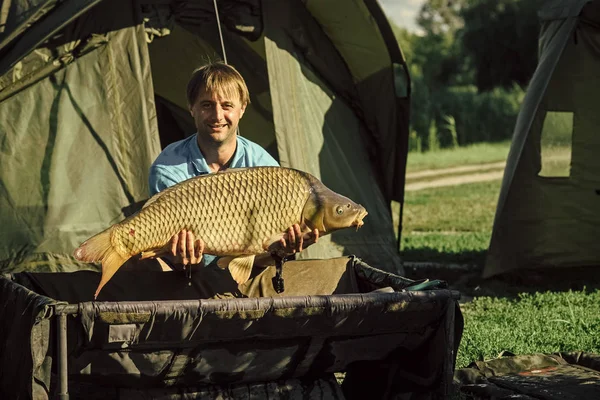 Pescatore con un trofeo. Pesca delle carpe, pesca, cattura dei pesci — Foto Stock