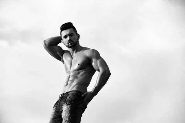 Werbung Jeans. Mann mit muskulösem Körper am blauen Himmel — Stockfoto