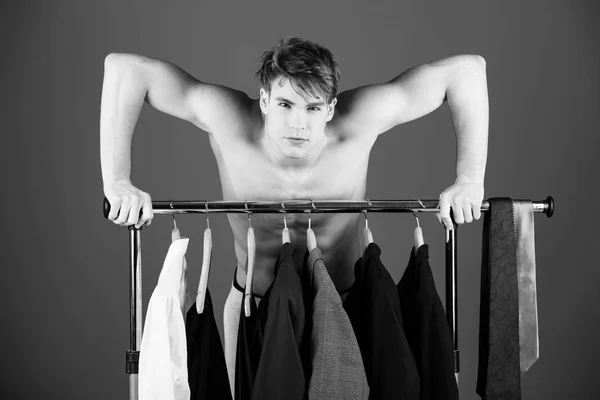 Pánské oblečení. oholený muž s nahý svalnatý trup stojí u šatní ramínko — Stock fotografie
