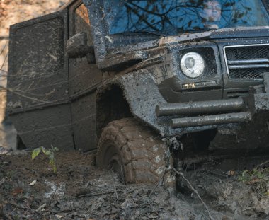 Kirli offroad araba açık kapı ile derin rut sıkışmış.