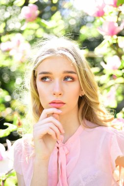 Rüya gibi yüz, Manolya çiçek, Doğa arka plan yakınındaki ihale sarışın kız. Bahar bloom kavramı. Bayan park güneşli bahar gününde yürür. Genç kadın zevk çiçek bahçesinde