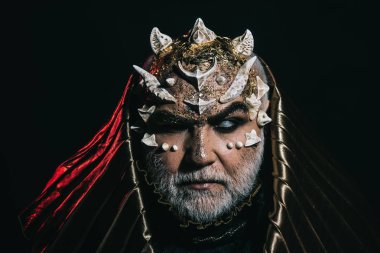 Büyücü metalik başlıklı karanlık, büyü ve fantezi concept tarafından emilir. İblis kafa ile keskin dikenler ve siğiller siyah arka plan üzerine. Sakallı adam uzaylı ya da canavar makyaj ve ışıltılı yüz