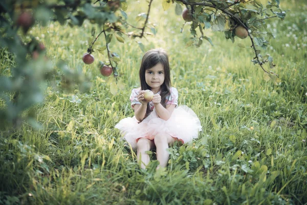 Niña sentada bajo el manzano —  Fotos de Stock