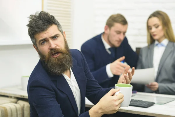 商务伙伴或商人在会议, 办公室背景。谈判概念。有胡子的男人在等待老板的决定时喝茶。商务谈判, 讨论交易条件 — 图库照片