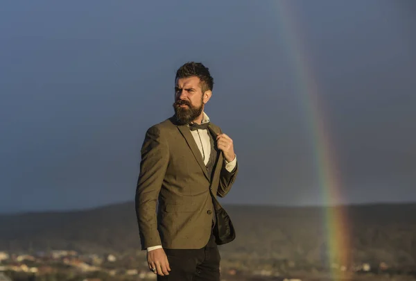 Man op de top van rock en regenboog — Stockfoto