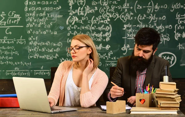 Moderne leraar hipster schrijven op grote schoolbord met wiskundige formule, leraar opzichten studenten, Smiling volwassen studenten tijdens de pauze in de klas interieur — Stockfoto
