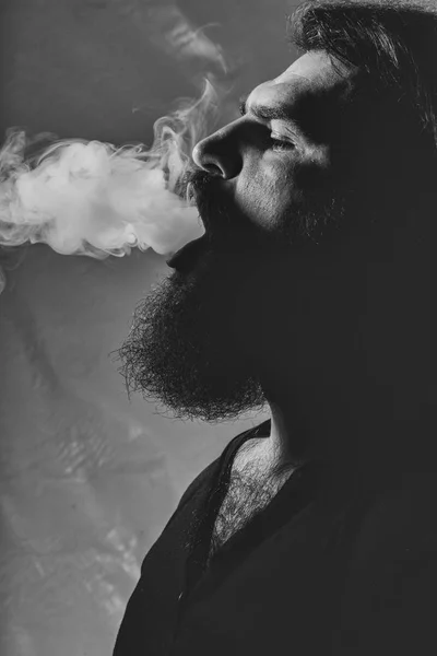 bad habits. Smoking kills. Bearded man with smoke