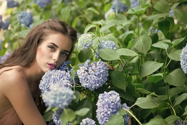 makyaj çiçekler yakınındaki kızla. Güzel kadın ve mavi çiçekler portre