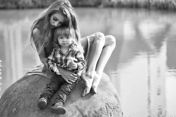 Madre e hijo están descansando. Hermana con hermano en piedra —  Fotos de Stock