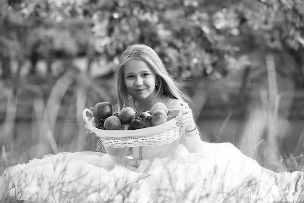 Chica con fruta naturaleza muerta. niña pequeña en vestido con cesta de frutas — Foto de Stock