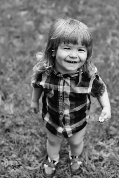 Geluk van het kind. Gelukkig jongetje op groen gras — Stockfoto