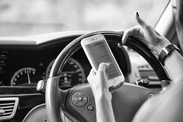 safety at the wheel. hands with smartphone and watch