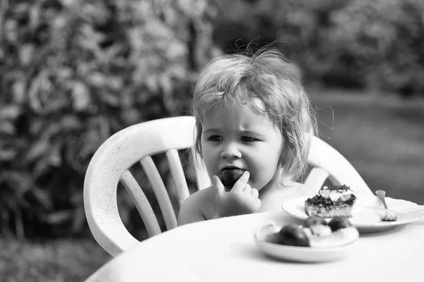 Baby boy eats plum — Stock Photo, Image