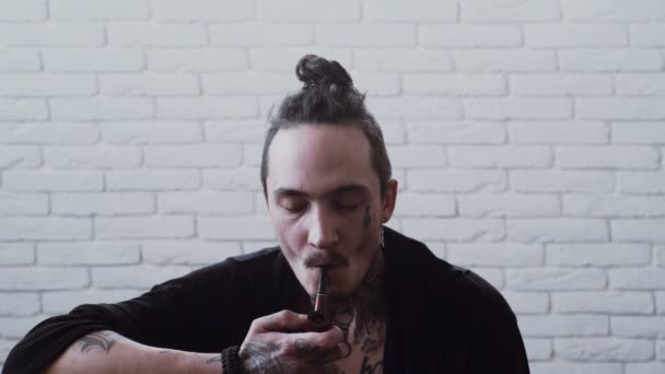 男の喫煙パイプ。ドレッドヘアを持つラスターの喫煙者。悪い習慣、中毒。不健康なライフ スタイルのコンセプトです。濃度. — ストック動画