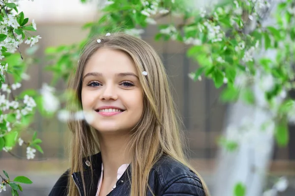 Sommaren eller våren mode och skönhet. Sexig kvinna med långt hår i sommar park. utseendet på flicka nära blommande träd. sensuell modell med smink efter frisör. flicka i casual kläder utomhus — Stockfoto