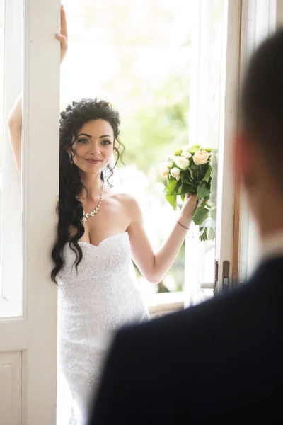 De glimlach van de gelukkige bruid op bruidegom. Vrouw en man op trouwdag. Sensuele vrouw met bruids make-up en kapsel. Mode meisje met glamour uitstraling en schoonheid. Bruiloft concept. liefde en romantiek — Stockfoto