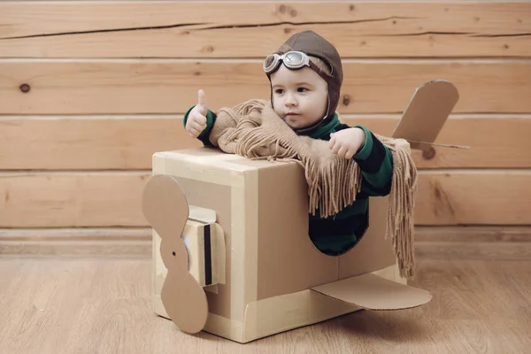 Cardboard plane with childhood, little boy pilot. — Stock Photo, Image