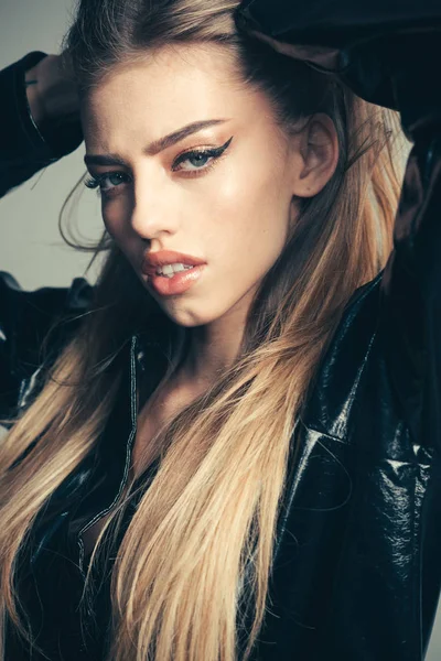 Trendy girl with makeup on sensual face. Fashion cosmetics for skincare. Sexy woman with stylish long hair in black leather coat. Beauty and hairdresser. Makeup look for woman with soft skin — Stock Photo, Image