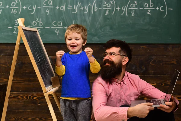 Ragazzo felice che completa il compito a scuola. Ragazzo eccitato in piedi accanto a insegnante sorridente. Divertimento alla lezione — Foto Stock