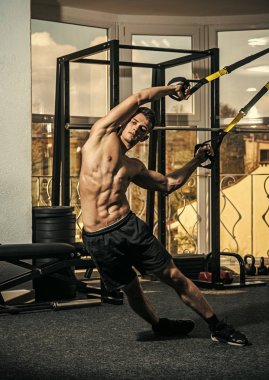 Spor ve spor salonu konsept. Adam çıplak ile gövde ve jimnastik salonu kas göğüs eğitim tadını çıkarın. Sporcu, atlet, kaslı adam mu egzersiz döngüler ile arka plan üstünde pencere
