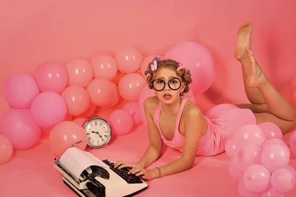 Pin up girl s psacím strojem. malá holčička v růžový prádlo tiskne na staré psací stroj — Stock fotografie