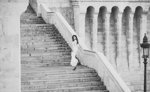 Modekonzept. Modebraut im weißen Hochzeitskleid auf der Treppe. Modemodel mit langen Haaren auf Treppen, Hochzeit — Stockfoto