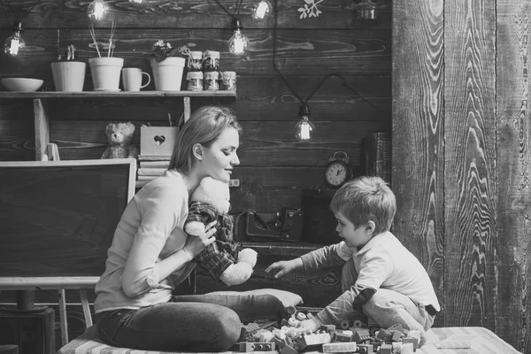 Anne ve çocuk arasındaki ilişki. Anne oğlu nazik ve dost olmak öğretir. Oyuncak ayı evde aile oyun. Anne ve çocuk ile yumuşak oyuncak oynamak. Kara tahta arka plan ile kreş