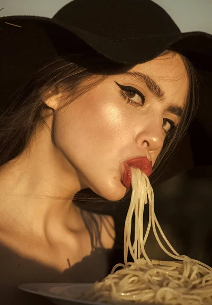 Crítico de restaurante. Placa feminina segurando de espaguete em uma mão e comendo com a boca . — Fotografia de Stock
