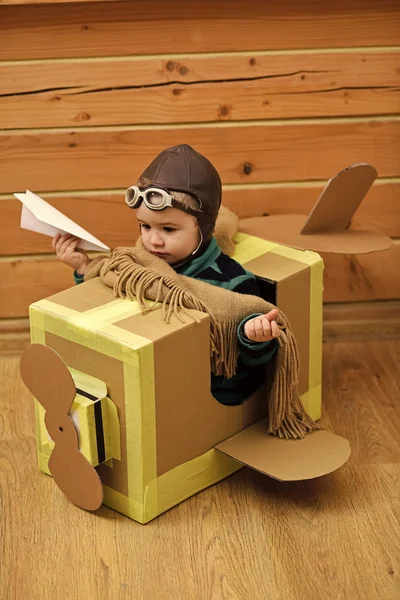 Begreppet avia transport. Liten drömmare pojke leker med en kartong flygplan. — Stockfoto