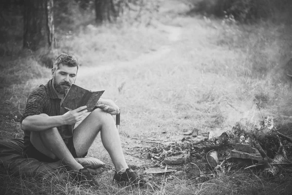 지속 가능한 교육, 환경 개념입니다. 남자 여행자 읽기와 모닥불 불꽃에서 음료 — 스톡 사진