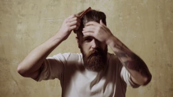 Un hombre muy guapo peinándose el pelo. joven peinarse el pelo delante del espejo . — Vídeos de Stock