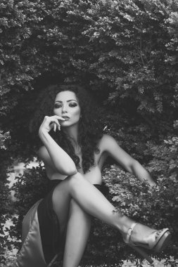 şehvetli kadın kıvırcık uzun saçlı. Şehvetli kadın çapraz ayaklı oturuyordu