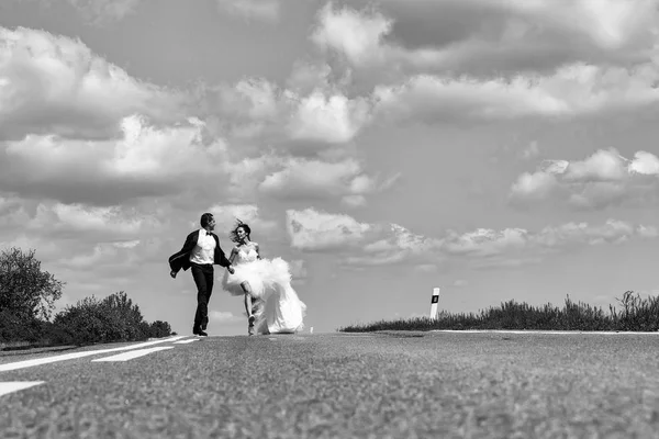 Encontro às cegas. casamento casal feliz correndo na estrada — Fotografia de Stock