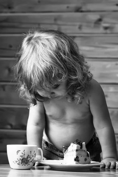 Barn i byn. liten pojke äter jordgubbstårta — Stockfoto