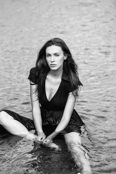 young sexy woman sitting in water