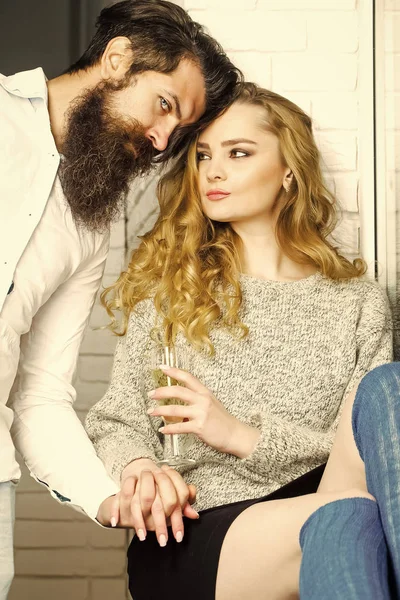 Couple in love hold hands. Woman with glass of wine look at bearded man