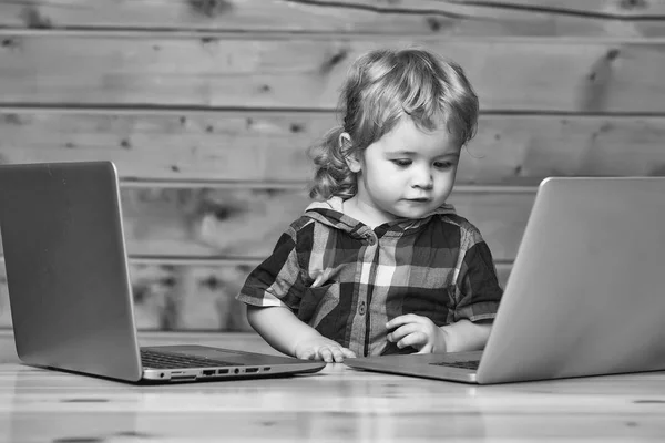 Criança aprende o trabalho do programador. Bonito menino joga em computadores — Fotografia de Stock