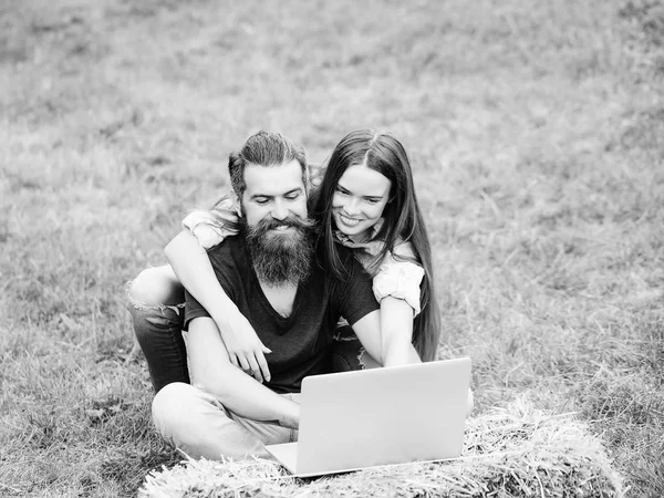 Vidám diákok. lány vagy boldog asszony és szakállas ember használ laptop, a természet — Stock Fotó